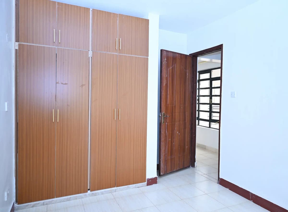 Bedroom with built-in wooden wardrobes and tiled floor