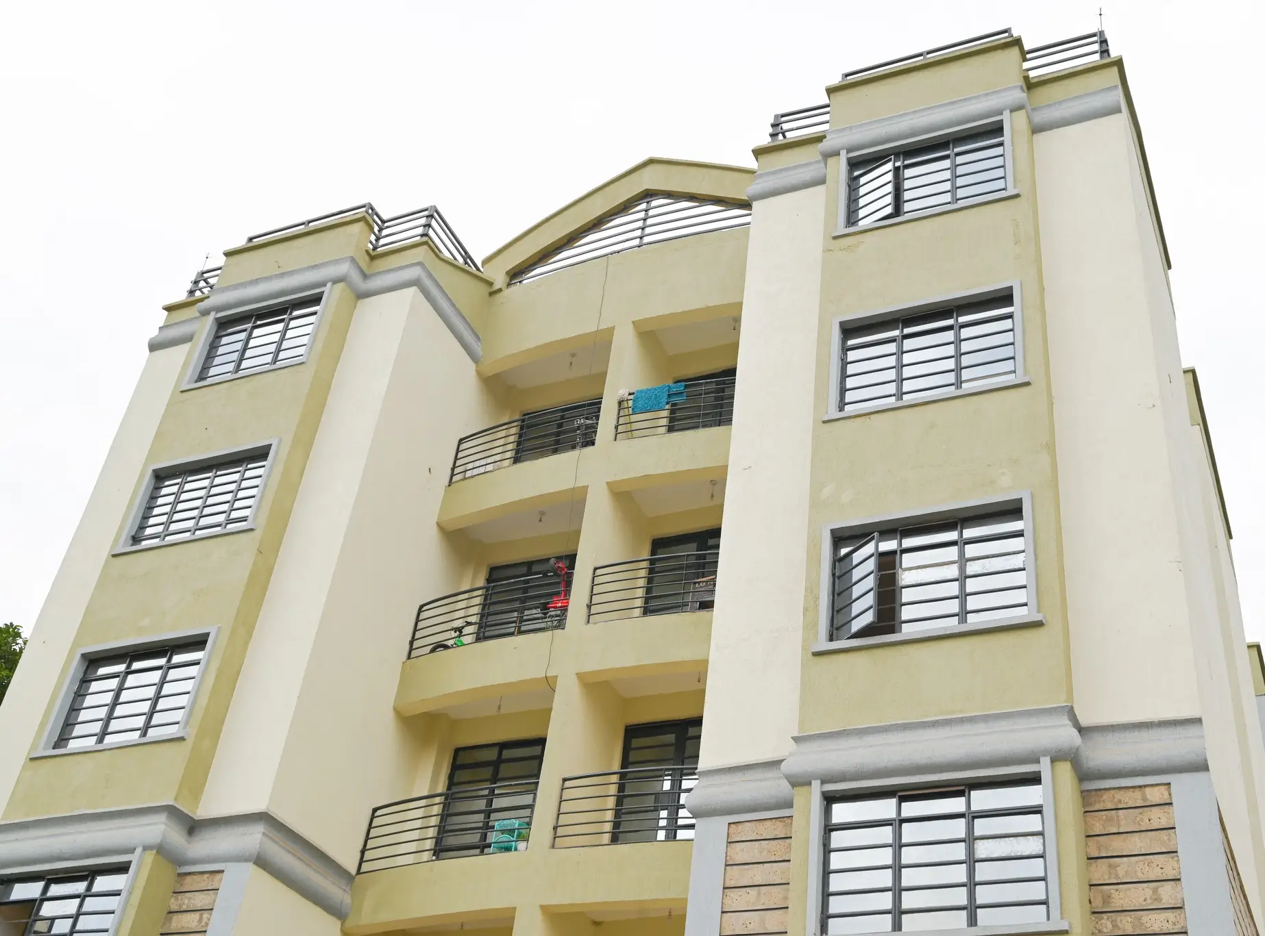 Multi-story residential building facade with balconies and louvered windows