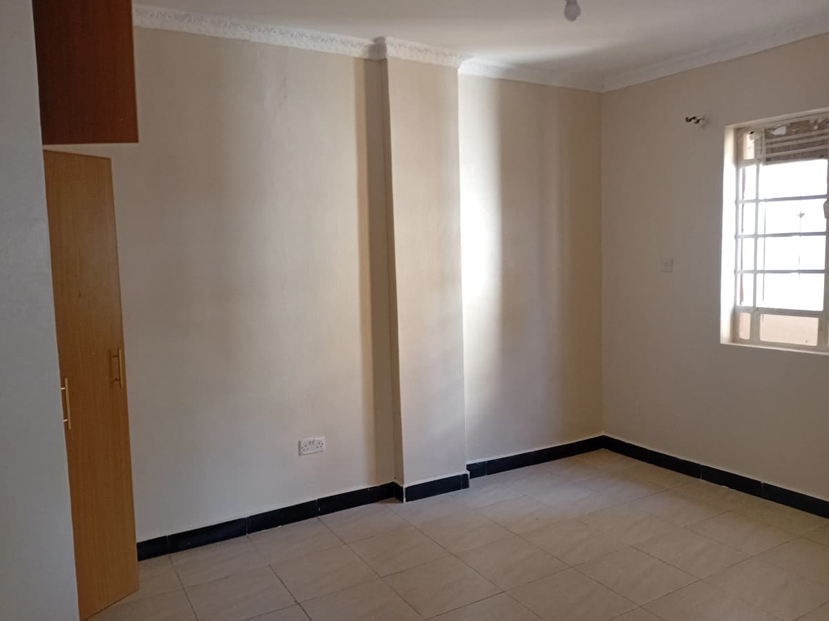 Empty bedroom with cream walls and contrasting black base trim