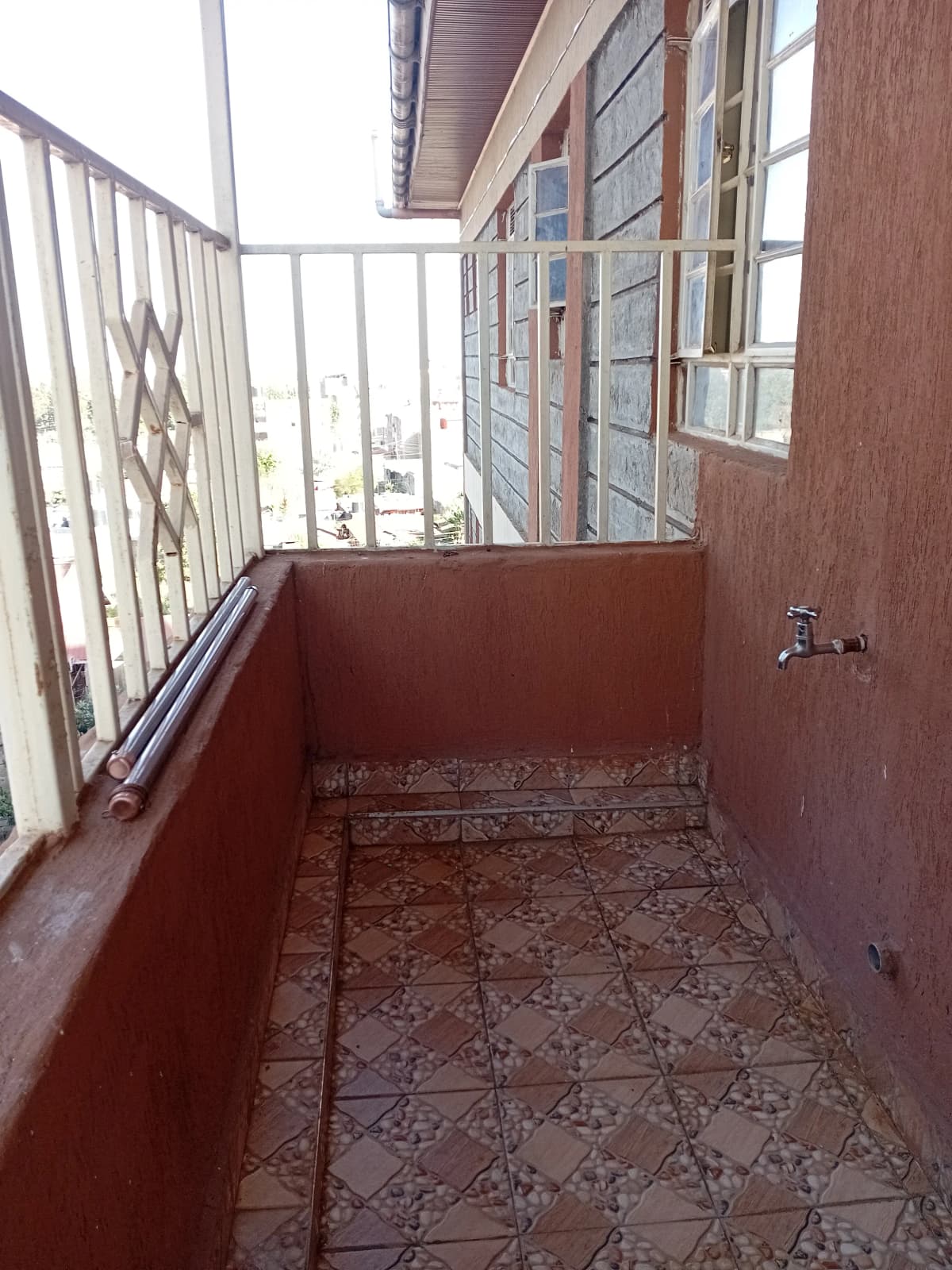 Enclosed balcony with railing and tiled flooring