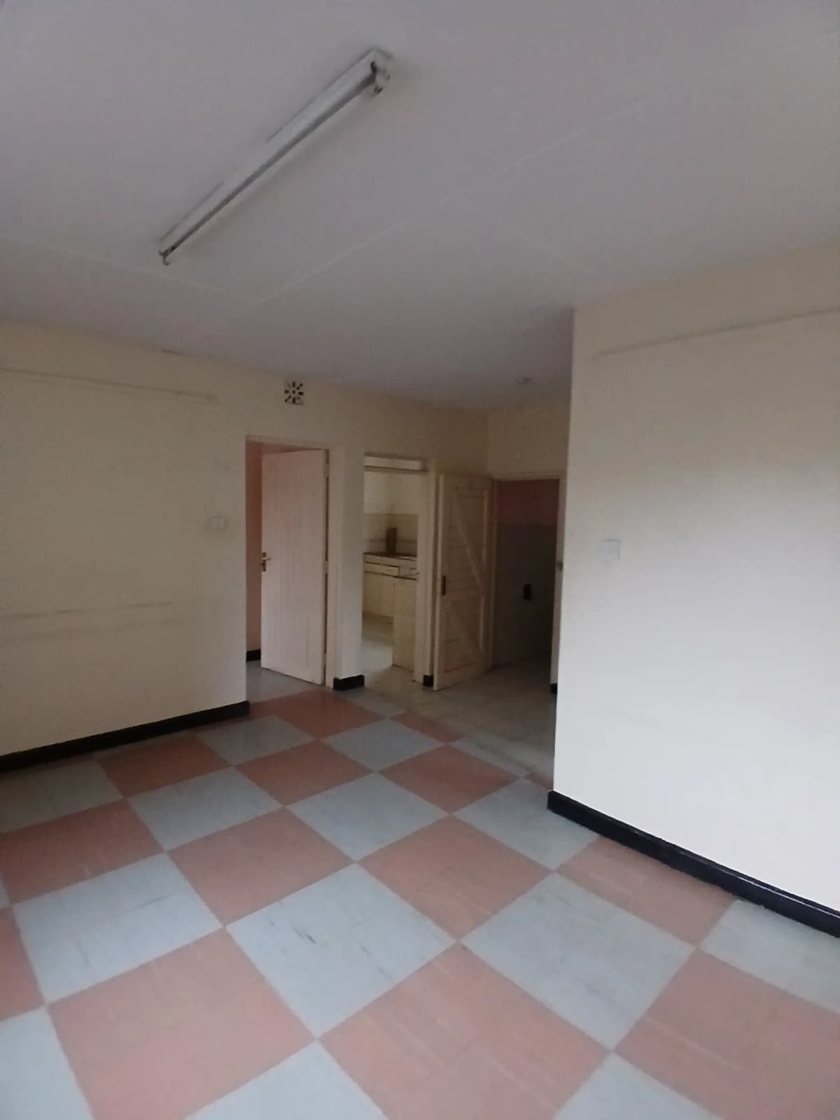 Empty corridor with checkered floor and multiple doorways