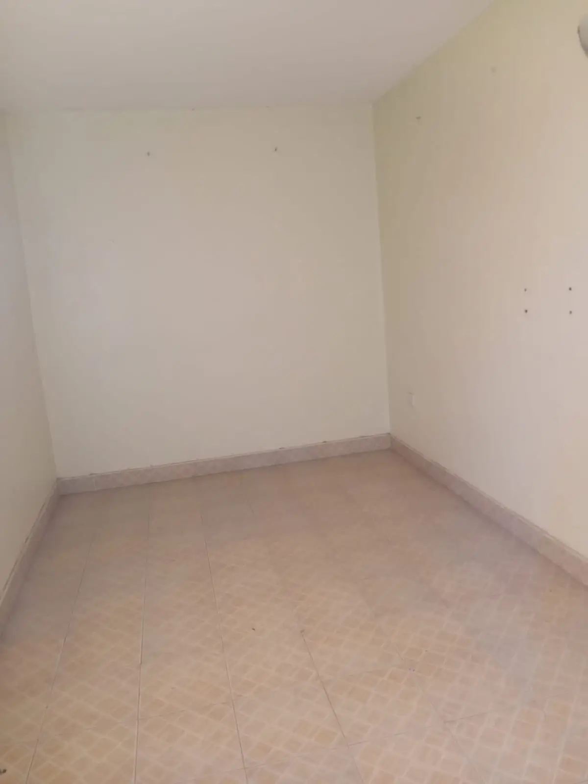 Empty bedroom with bare walls and concrete floor