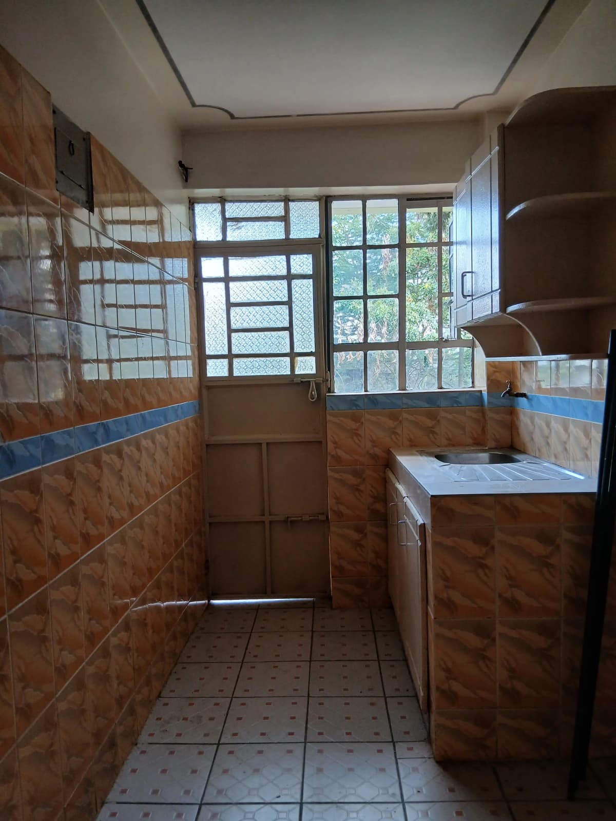 Galley kitchen with wooden cabinetry and large windows