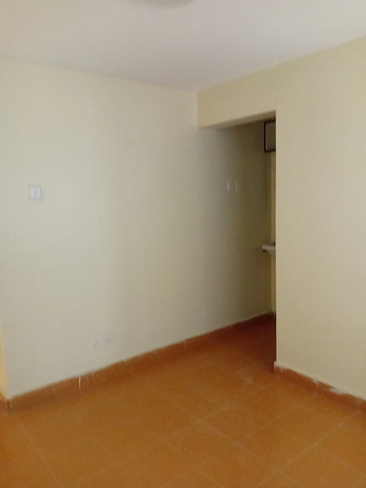 Empty bedroom with wooden floor and cream walls