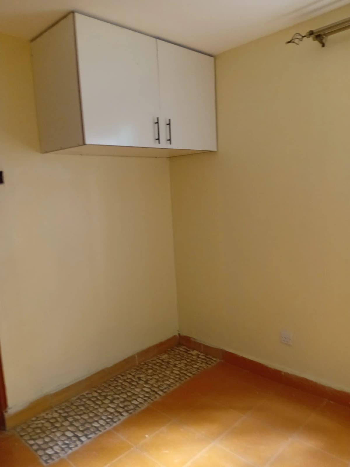 Compact pantry with white wall cabinet and tiled floor