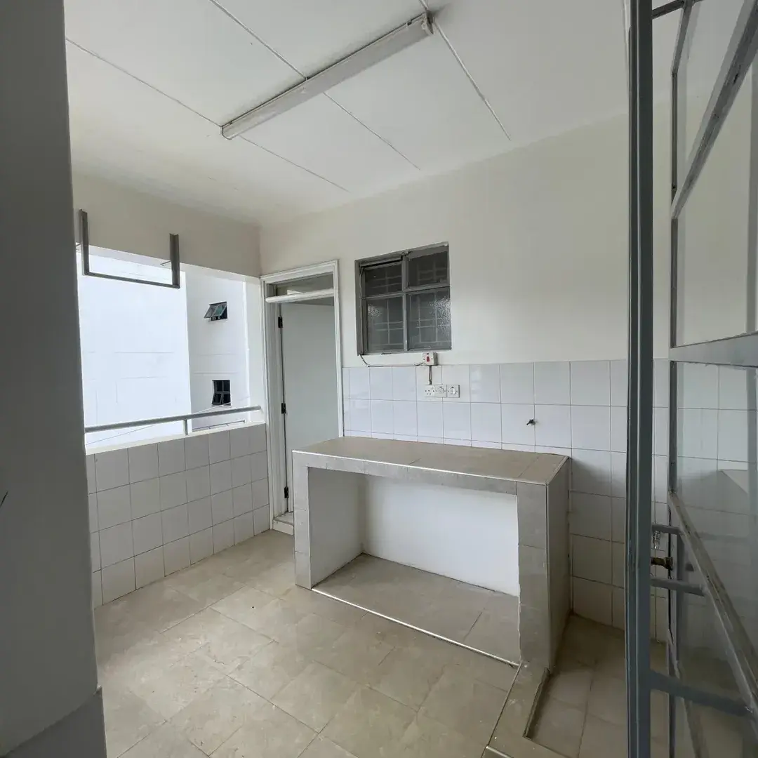 Minimal kitchen with concrete counter and white tile walls