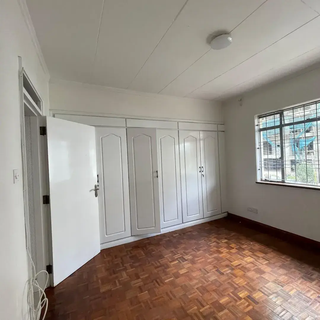 Spacious bedroom with built-in wardrobes and parquet flooring