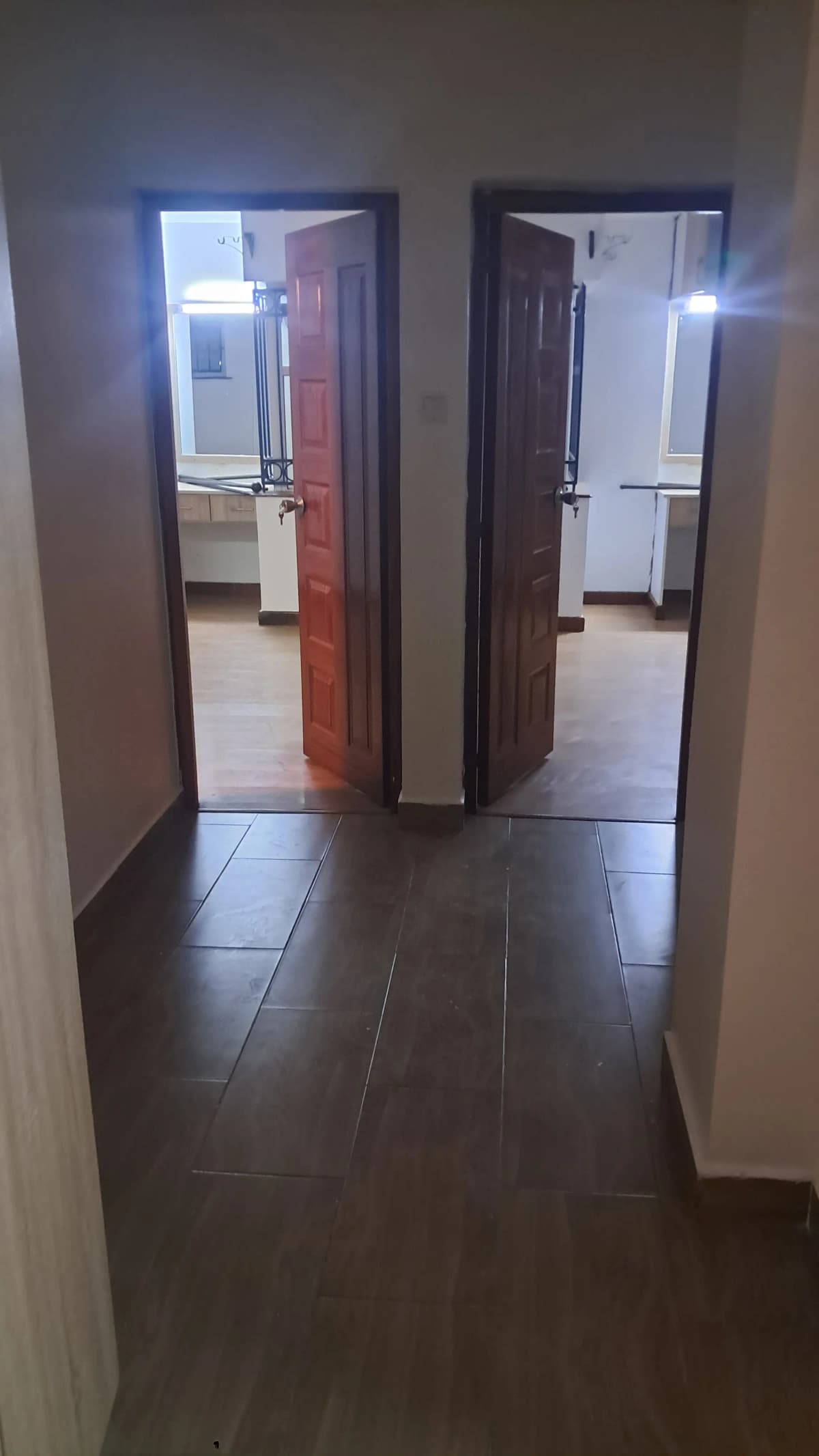 Hallway with dual doorways leading to separate rooms