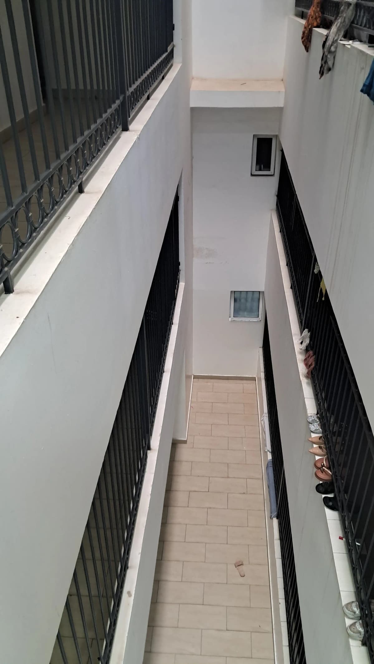 Narrow side passage with tiled floor and black railings