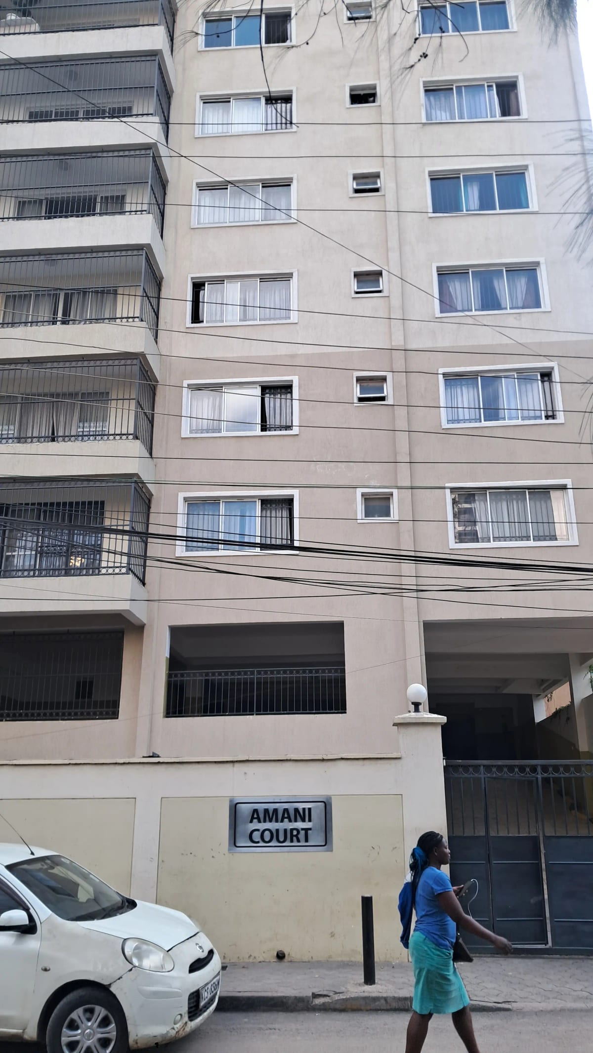 Multi-story residential building facade with ground floor parking