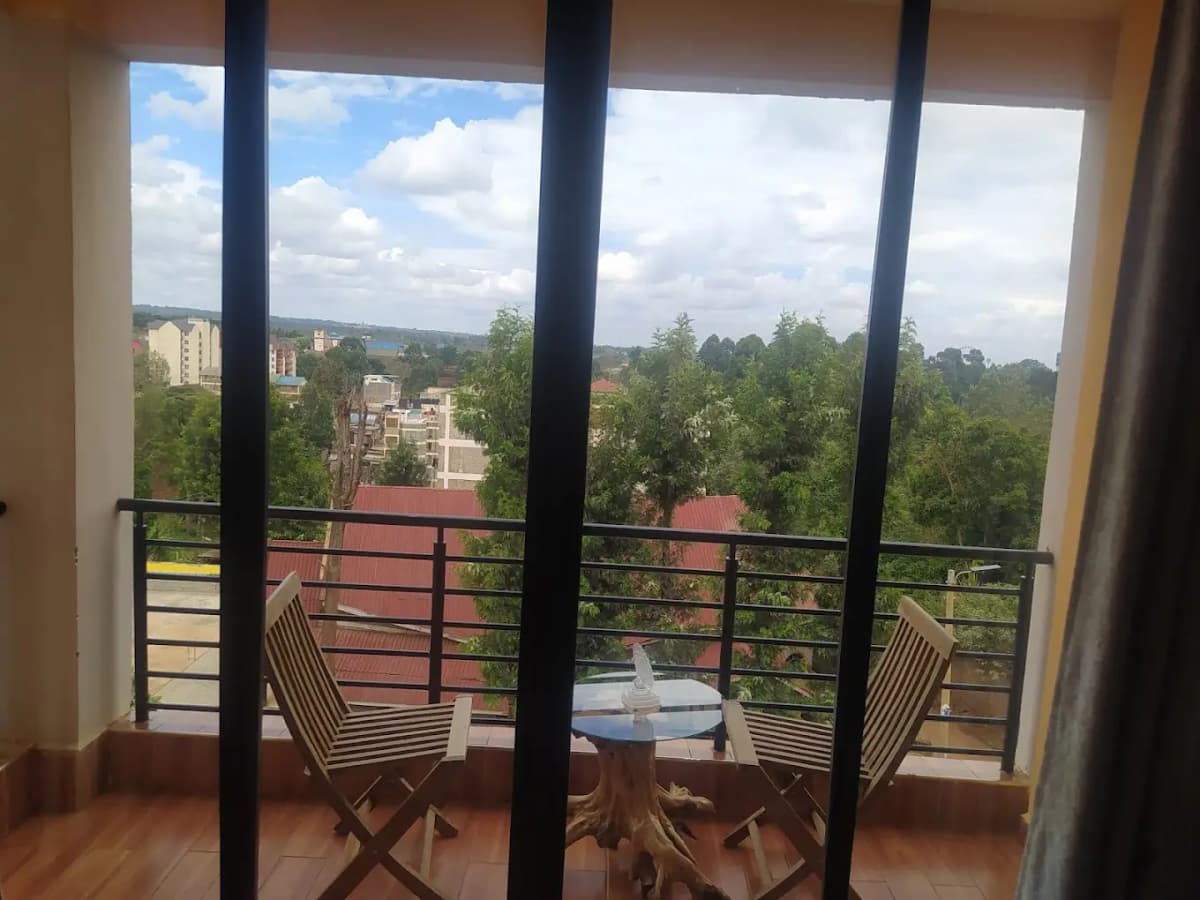 Elevated balcony with city and forest views, wooden seating