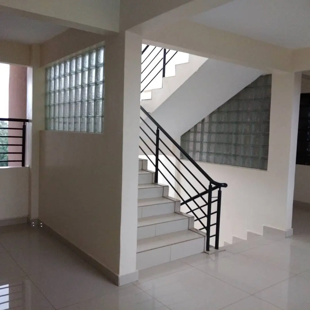Modern staircase with black railing in bright lobby space