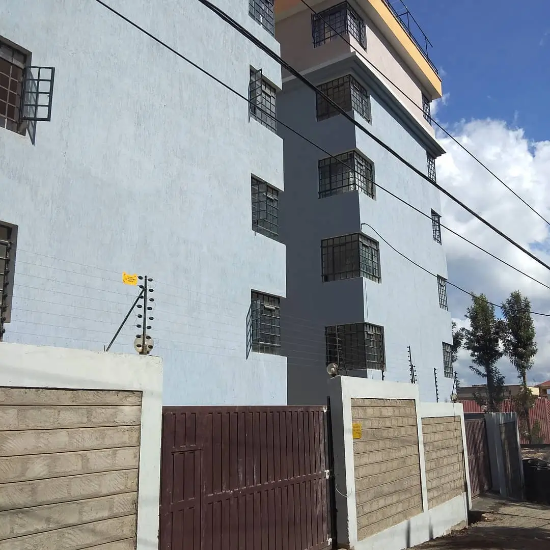 Multi-story residential building with compound walls and gate