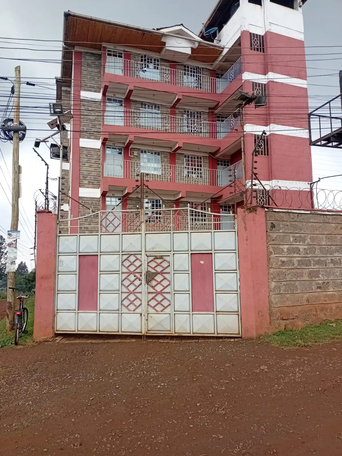 Multi-story residential building facade with pink and white finish