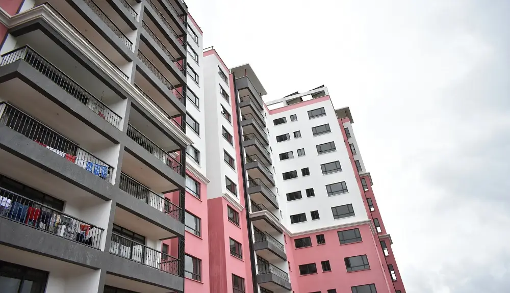 Multi-story residential building facade with pink and white panels