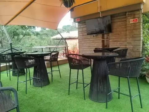 Covered outdoor dining terrace with green artificial turf