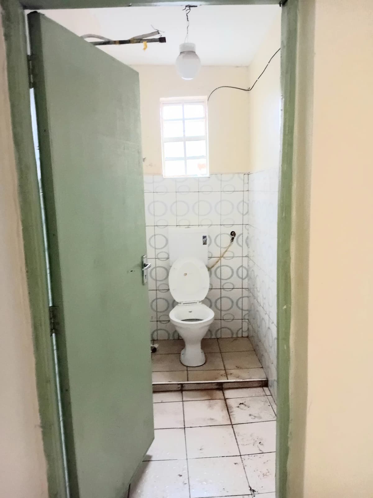 Simple bathroom with white tile flooring and pedestal toilet