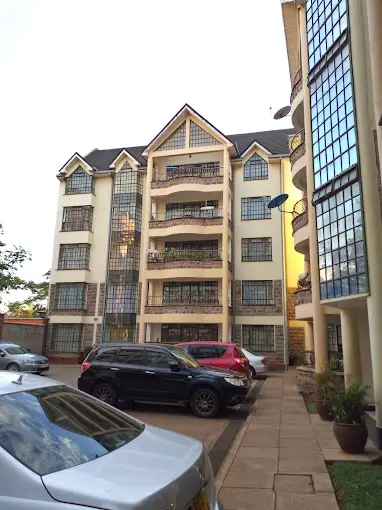 Multi-story residential building facade with ground-level parking bays