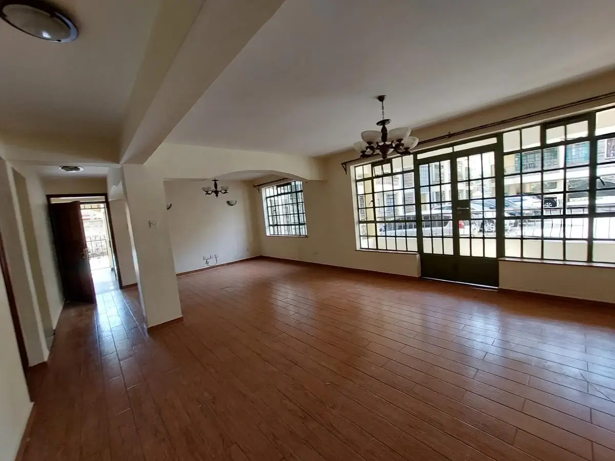 Spacious living room with wooden floors and large windows