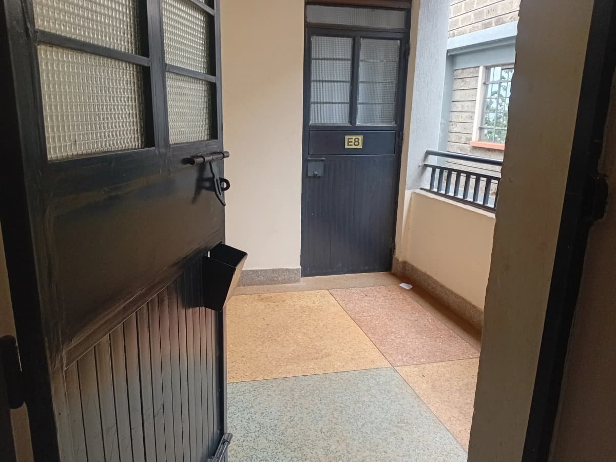 Building entrance lobby with dark door and tiled flooring