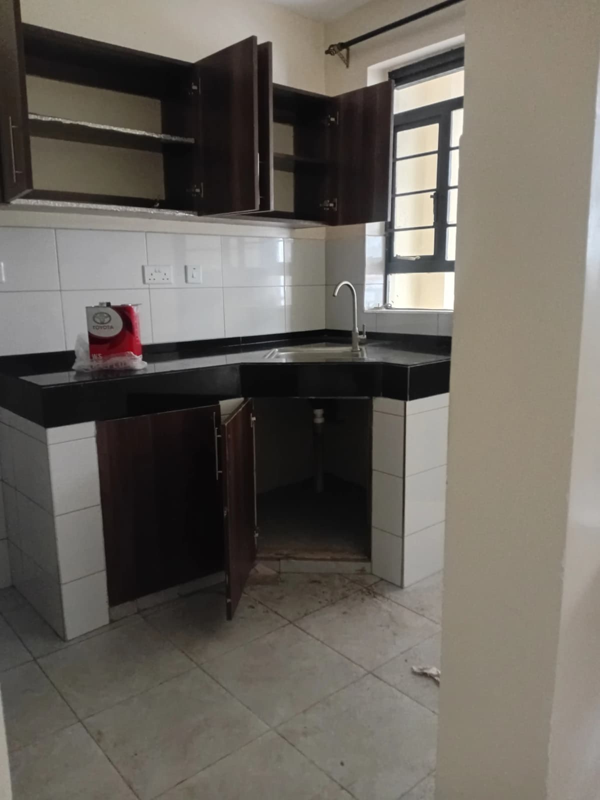 Compact kitchen with black cabinets and white tile backsplash
