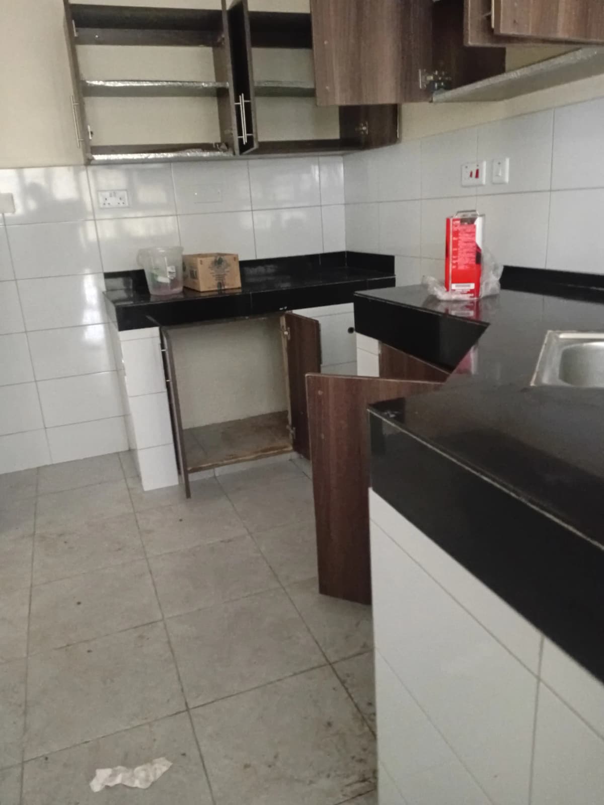 Compact kitchen with black countertops and white tile backsplash