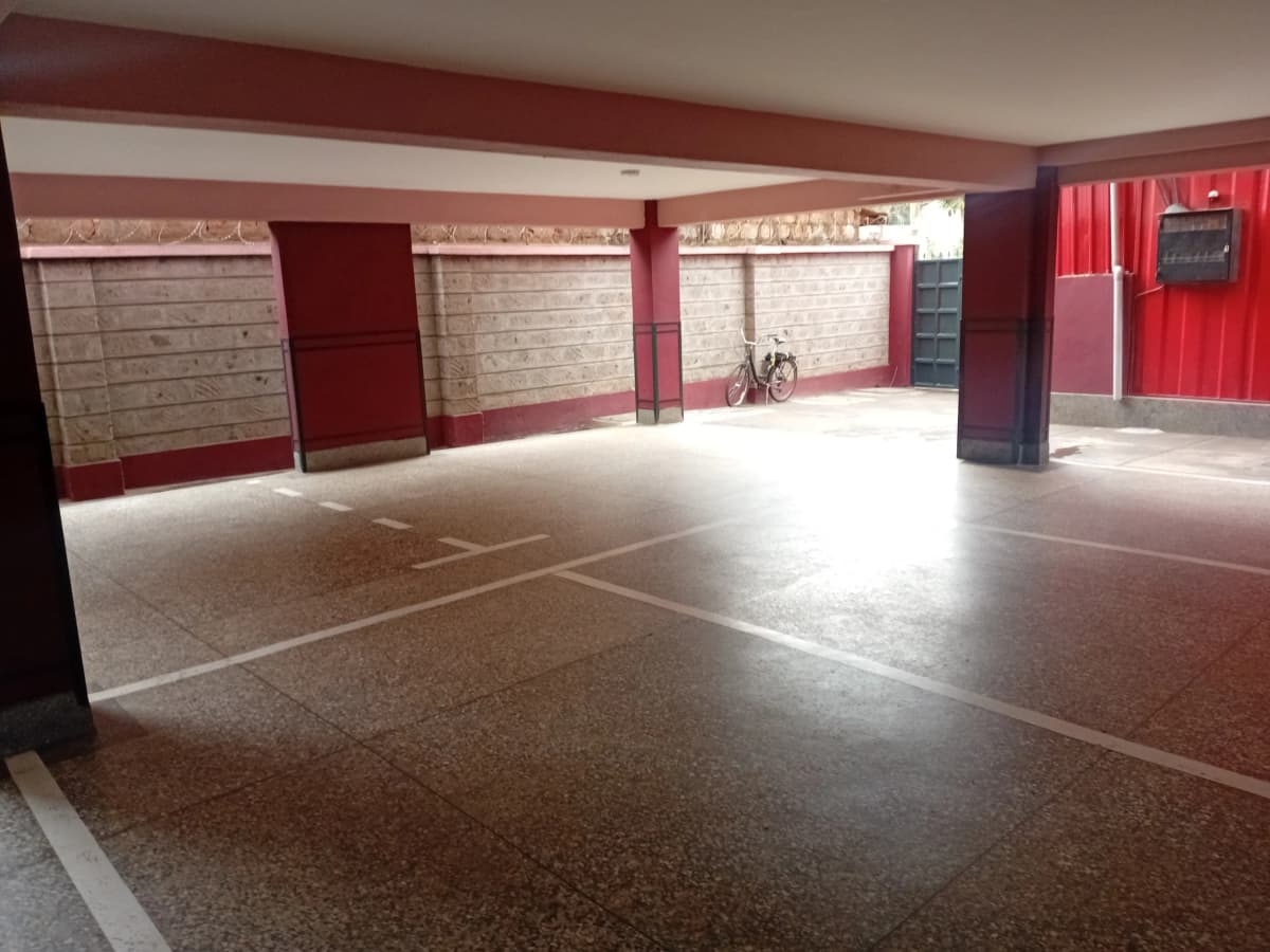 Large covered parking area with red accent walls and markings