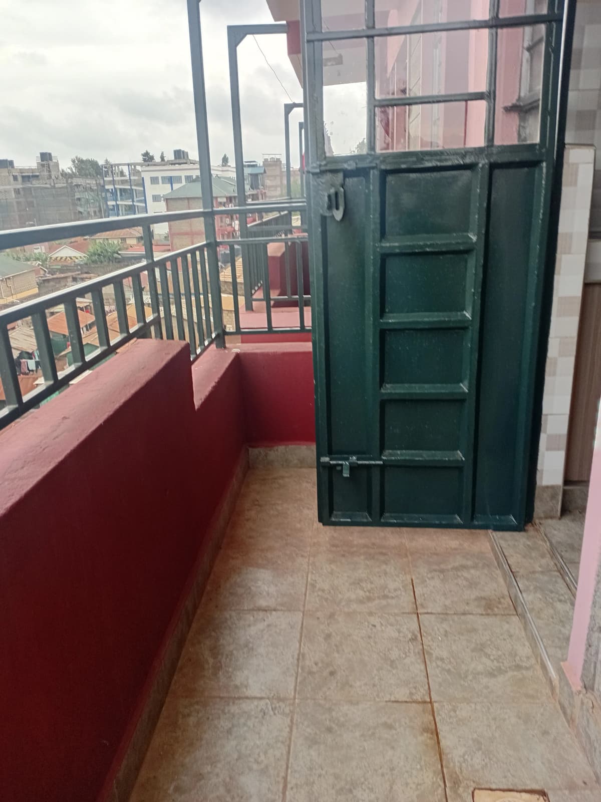 Elevated balcony with city skyline views and green door