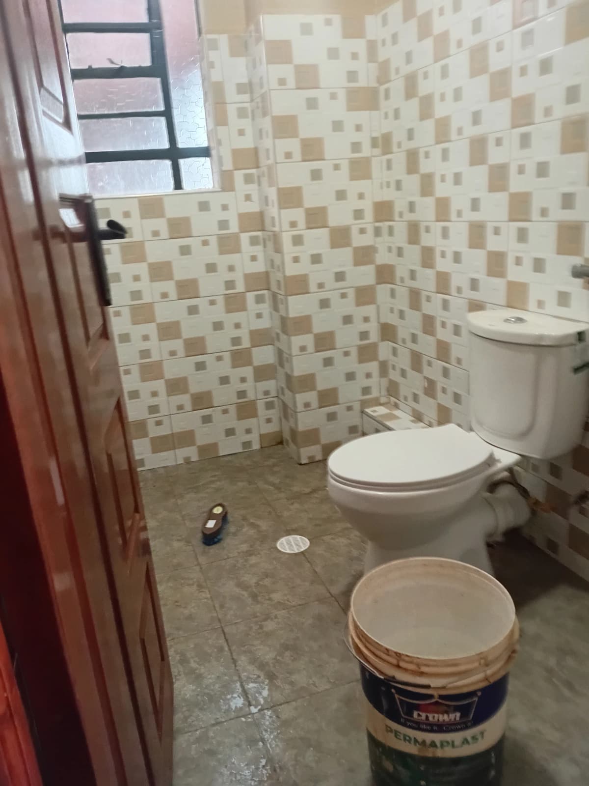 Small bathroom with checkered tile walls and white toilet