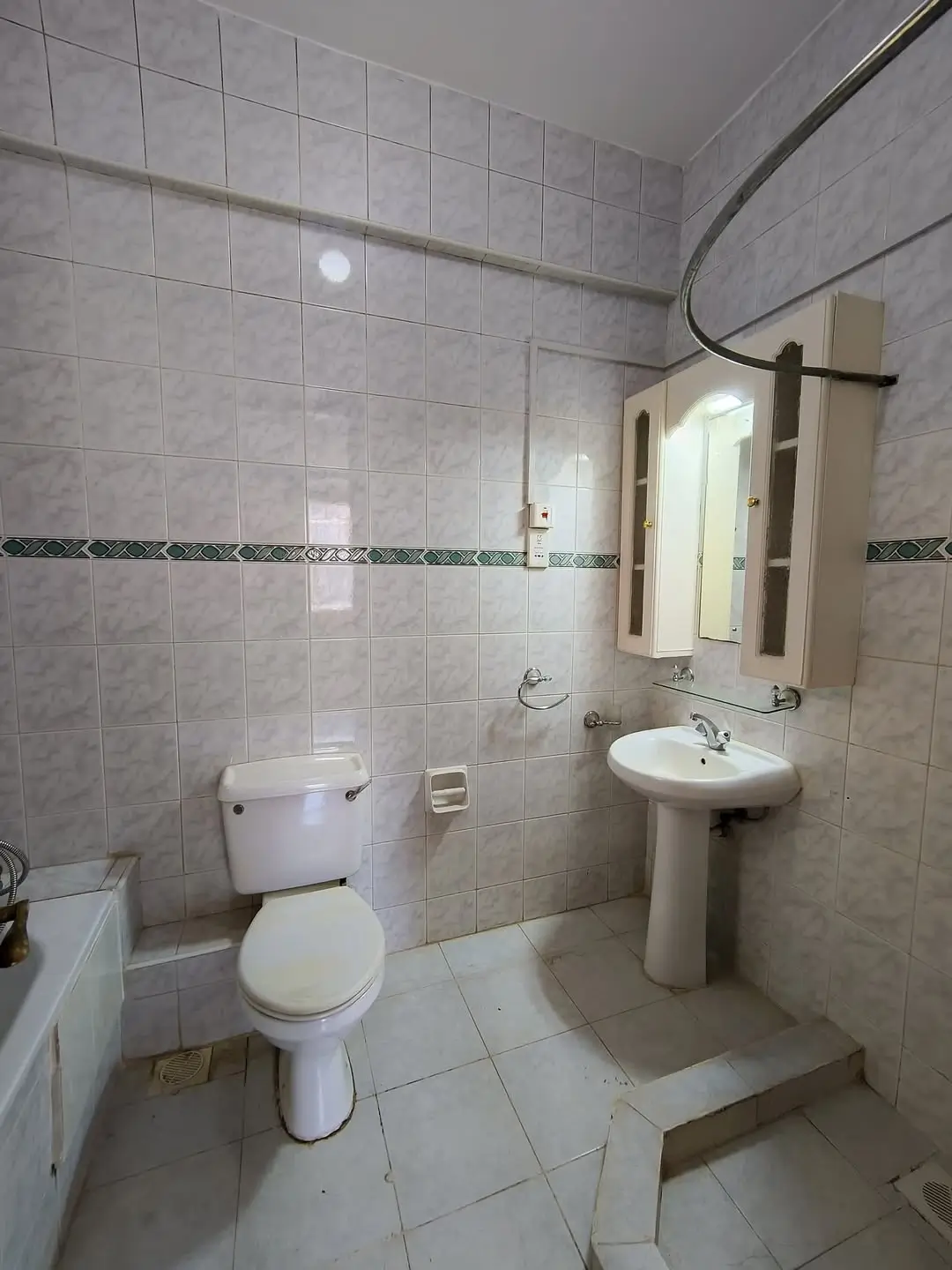 Tiled bathroom with pedestal sink, toilet, and mirror