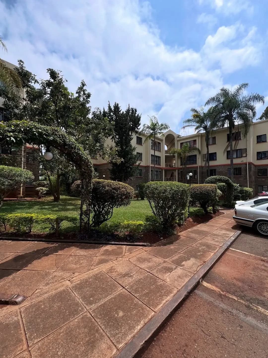 Lush compound grounds with manicured hedges and lawn