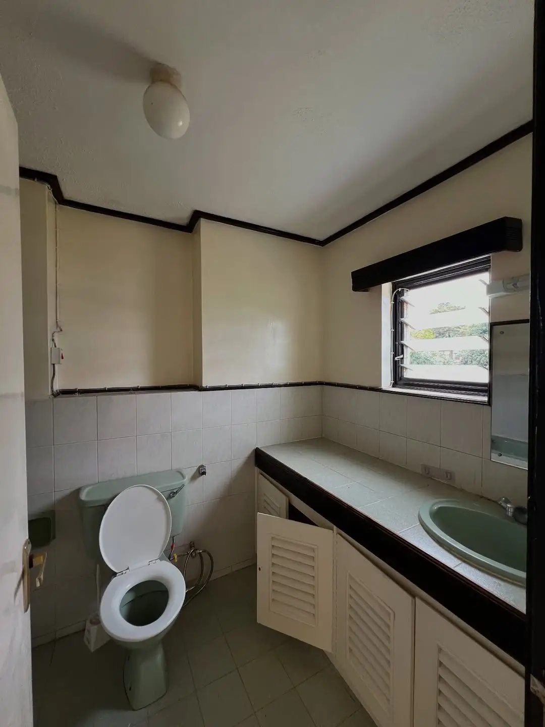 Bathroom with toilet, sink vanity, and window view