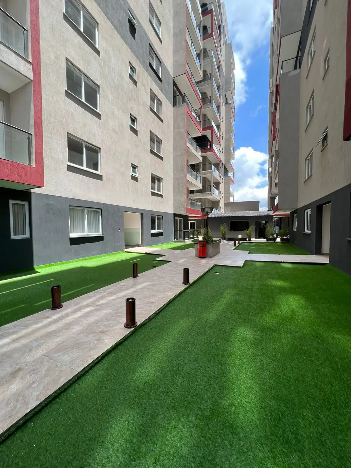 Modern compound courtyard with artificial turf and landscaping
