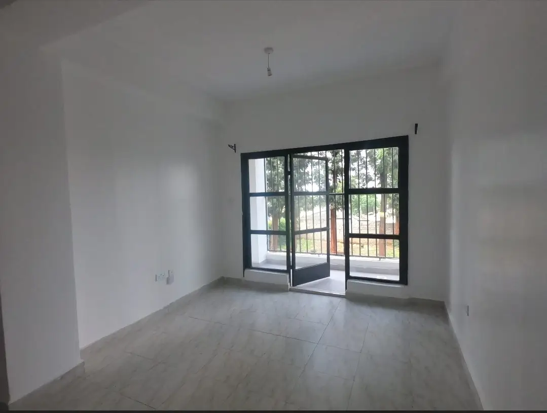 Bright empty living room with glass doors opening to balcony