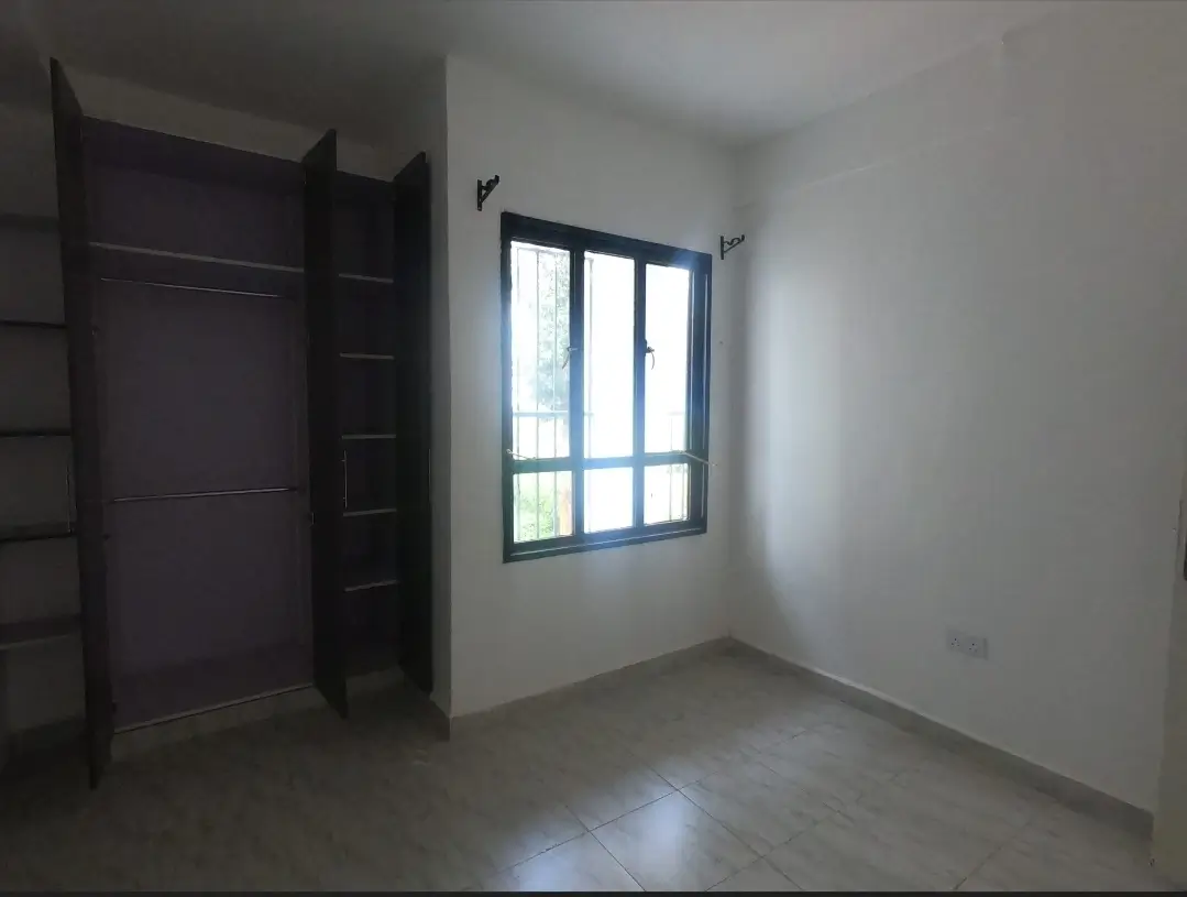Unfurnished bedroom with built-in wardrobe and window