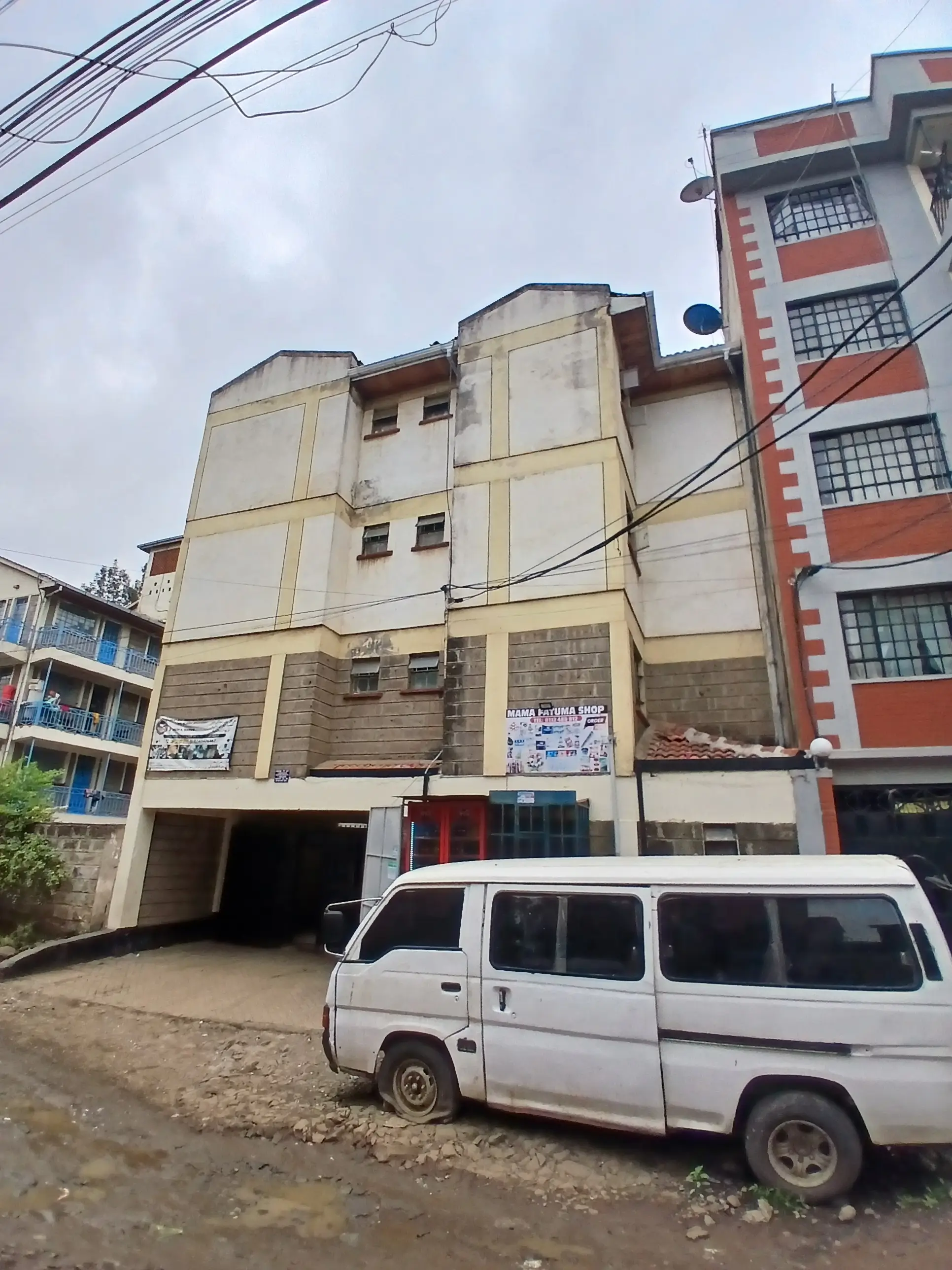Multi-story residential building facade with ground-level parking entrance
