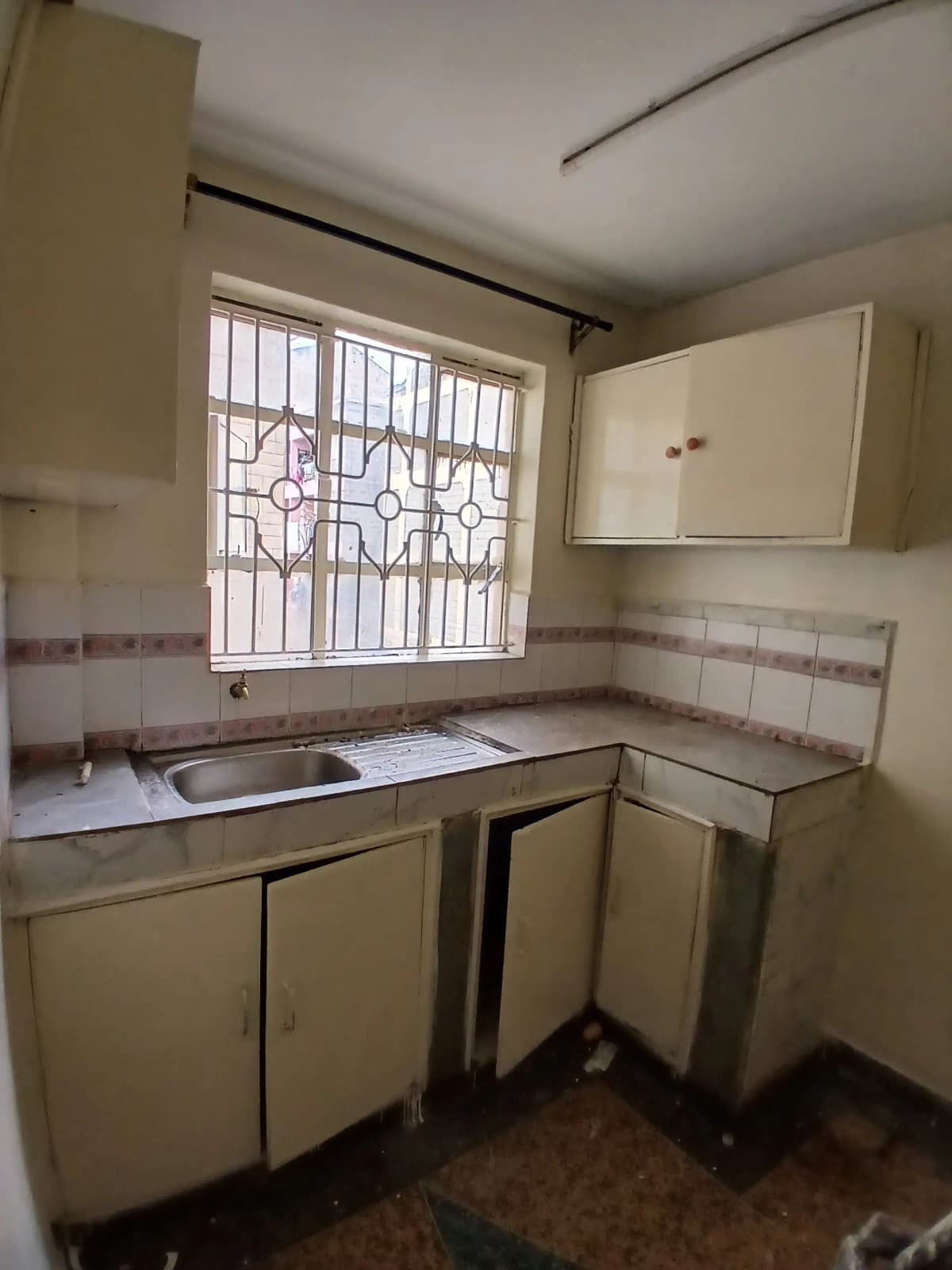 Compact kitchen with stovetop, sink, and wall-mounted cupboards