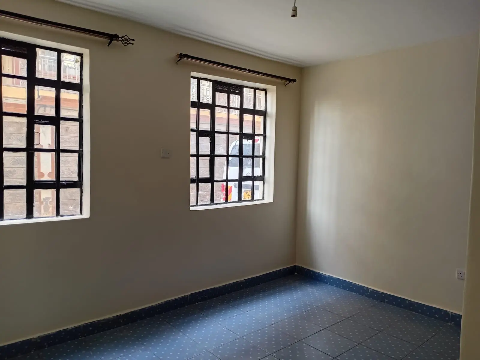 Unfurnished bedroom with large windows and blue tile flooring