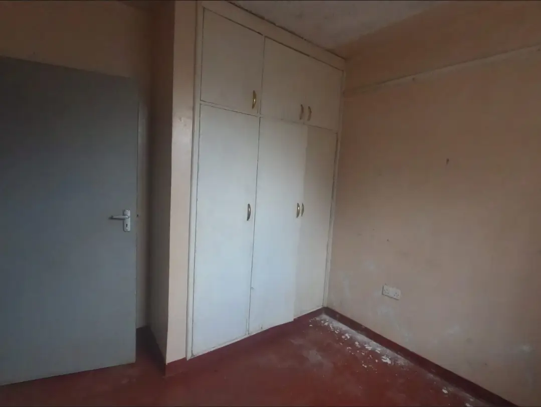 Bare bedroom with built-in wardrobes and wooden flooring