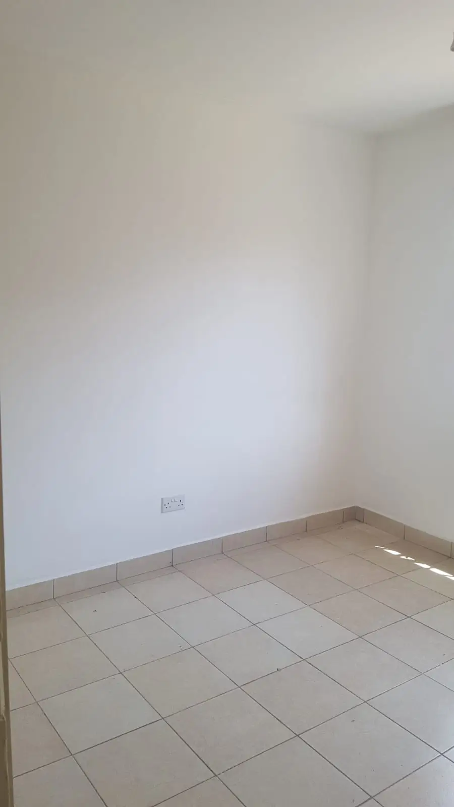 Bare bedroom with tiled floor and white walls
