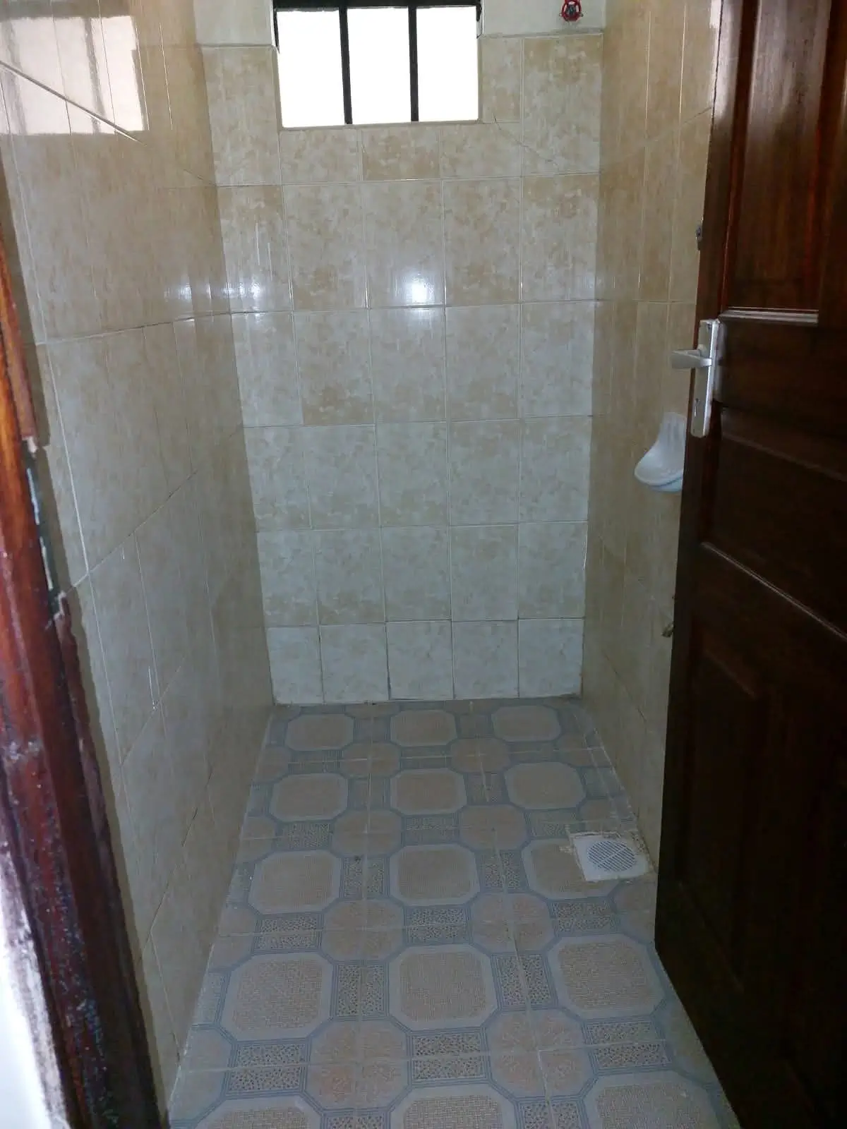 Tiled bathroom with glass shower enclosure and window