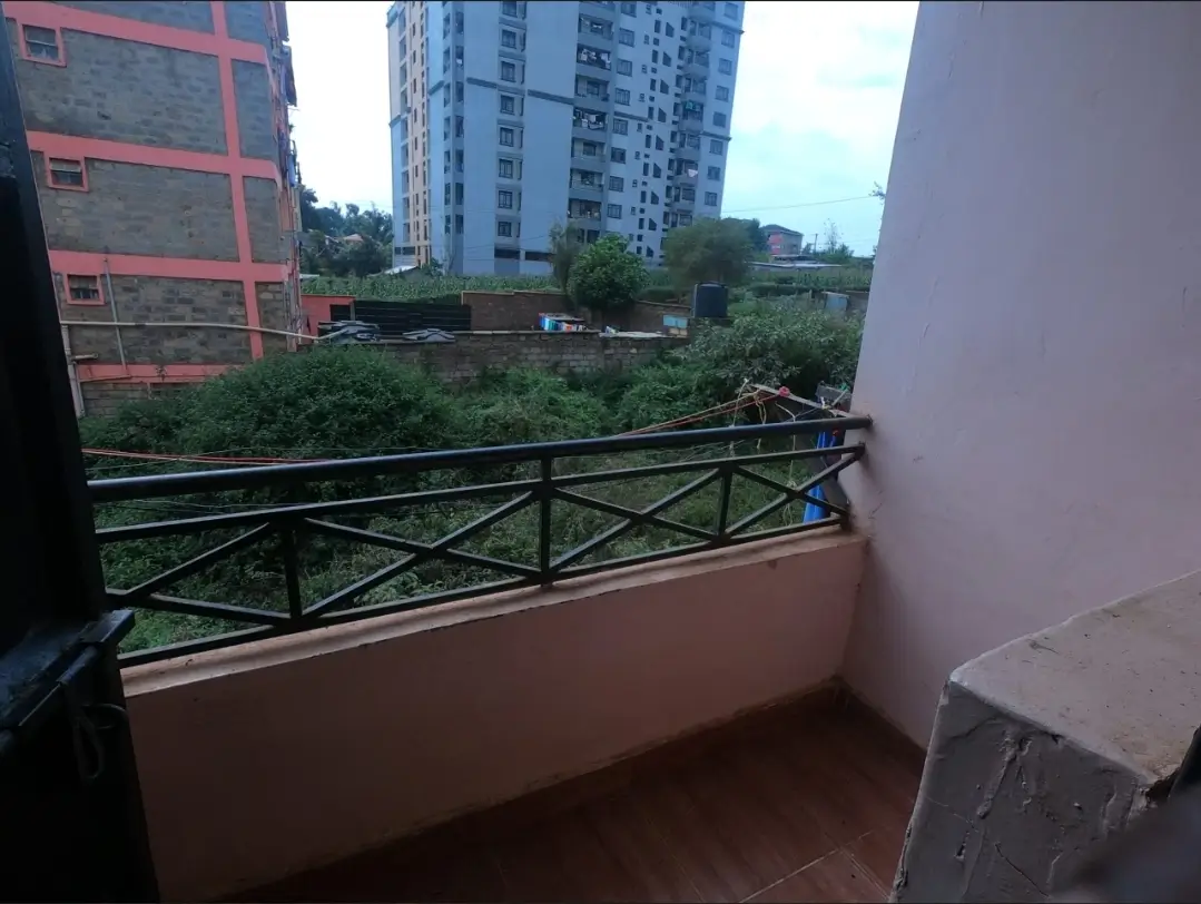 Balcony with black railing overlooking residential compound