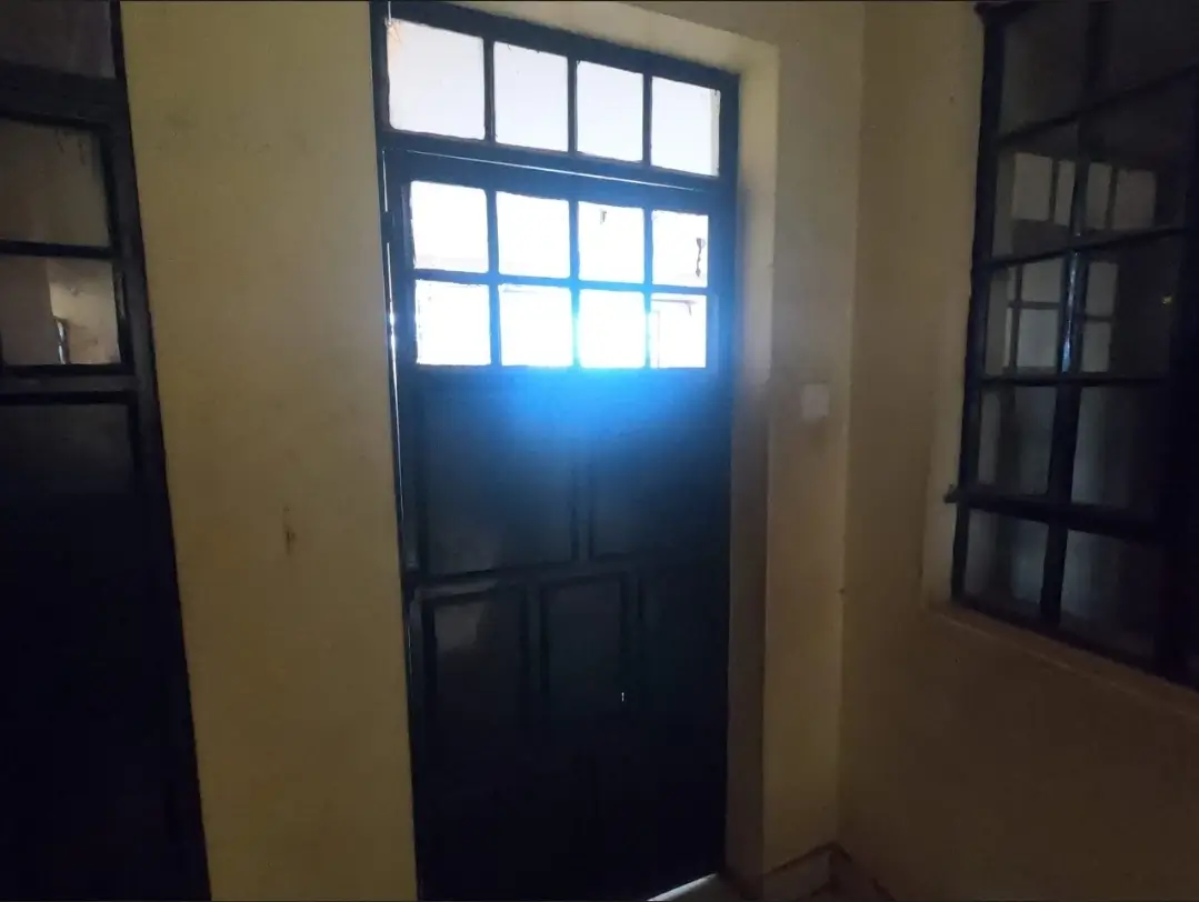 Building entrance hallway with blue-framed glass door and windows