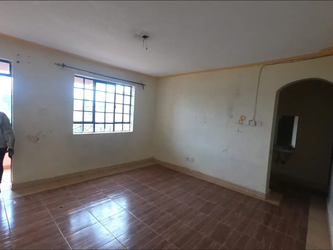 Empty living room with tiled floor and barred windows