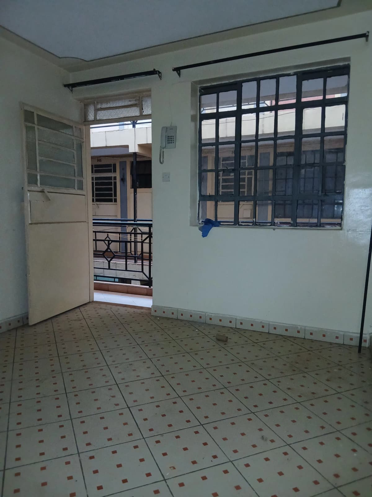 Compact kitchen with tiled floor and barred window opening