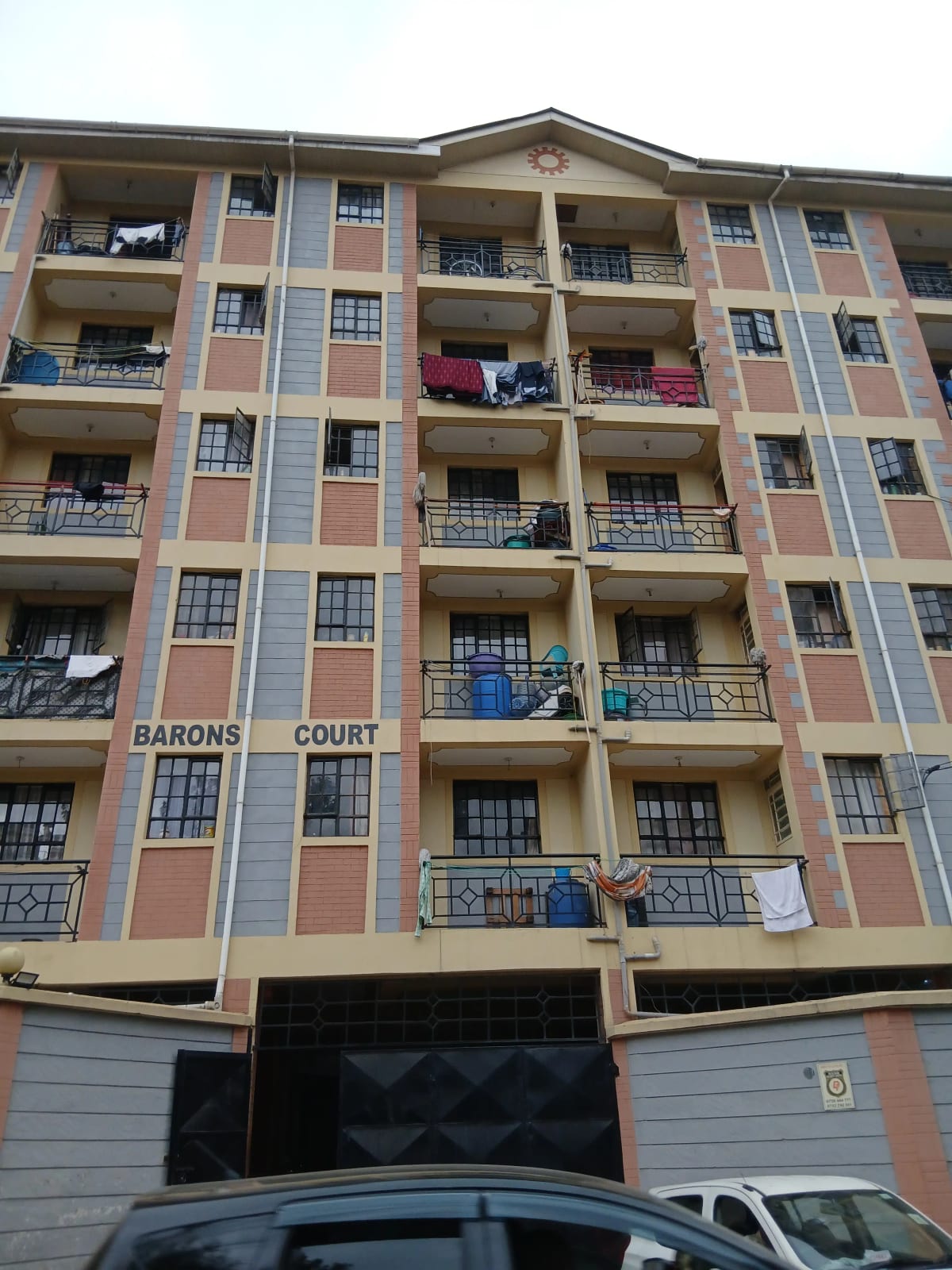 Multi-story residential building facade with balconies and ground parking