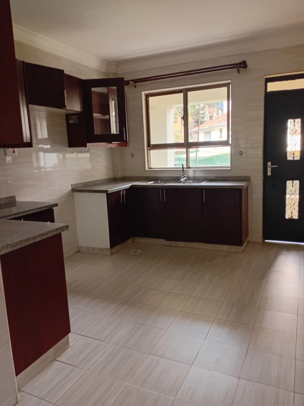 Modern kitchen with dark cabinets and tile flooring