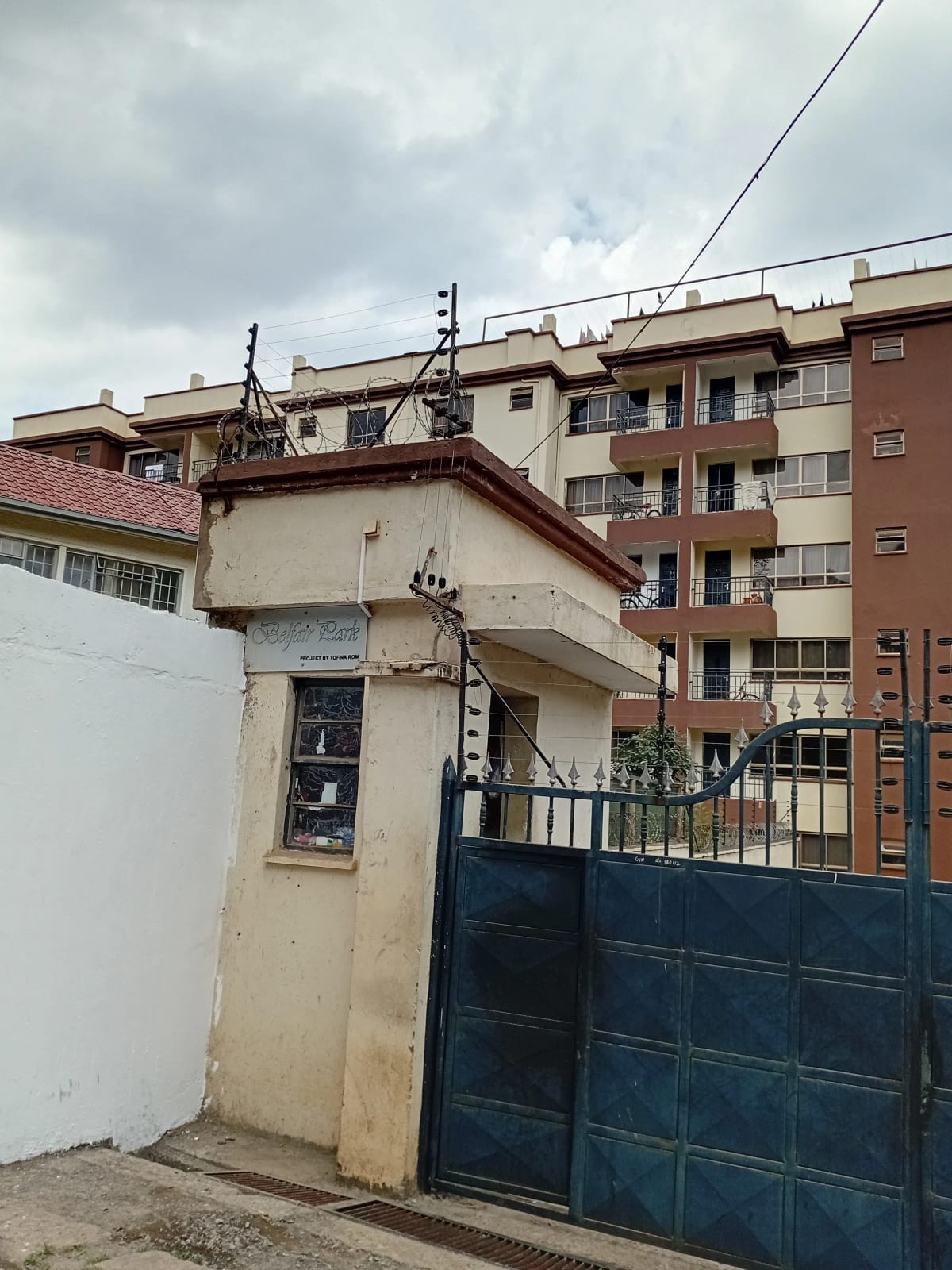 Multi-story residential building with blue metal gate entrance