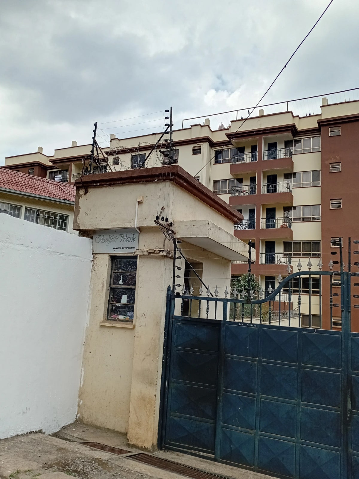 Multi-story residential building with blue metal gate entrance
