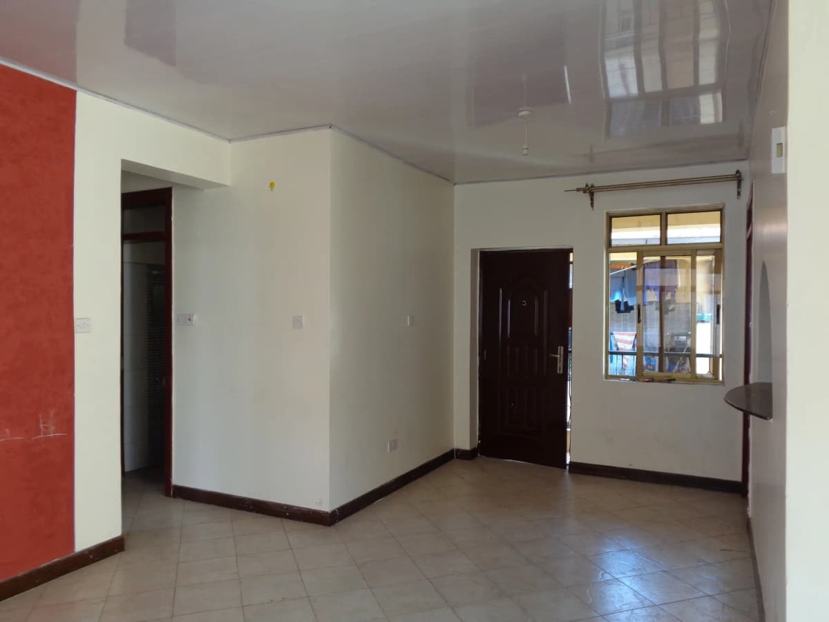Spacious open living area with tiled flooring and neutral walls